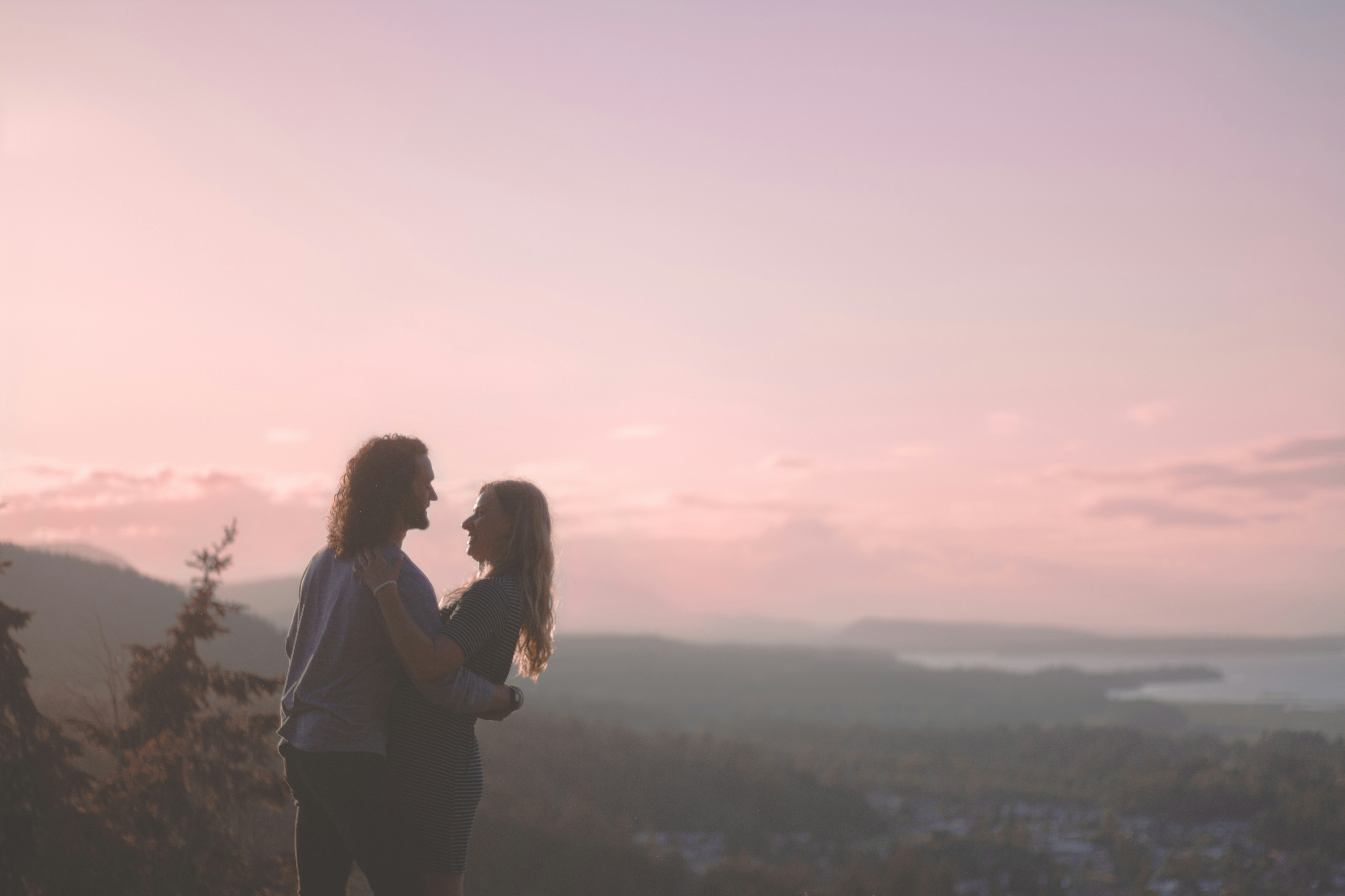 man and woman standing on top of the mountain during daytime